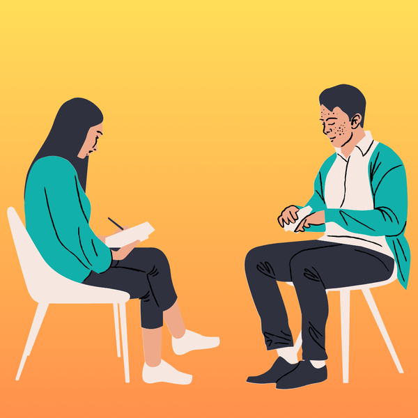 a woman sitting and taking notes across from a man sitting and talking